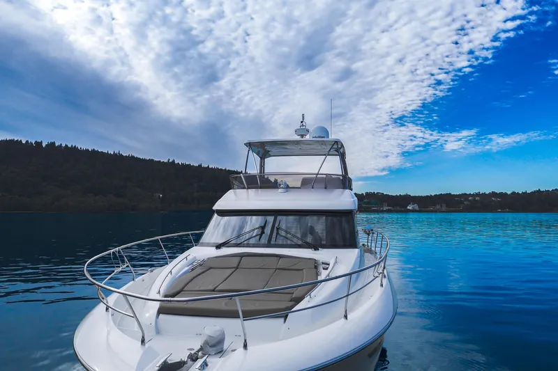 Luna Maris Yacht Photos Pics Luxury 2016 Prestige 550 yacht on serene blue water under a partly cloudy sky.