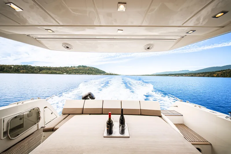 Luna Maris Yacht Photos Pics Luxury yacht Prestige 550 cruising on a serene lake, featuring a wine setup on deck.