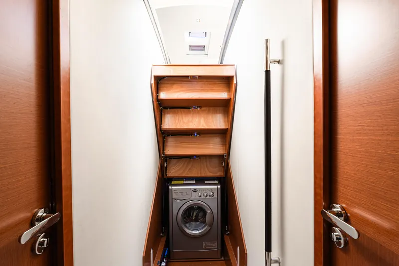 Luna Maris Yacht Photos Pics Laundry area with washing machine and wooden shelves on a 2016 Prestige 550 yacht.