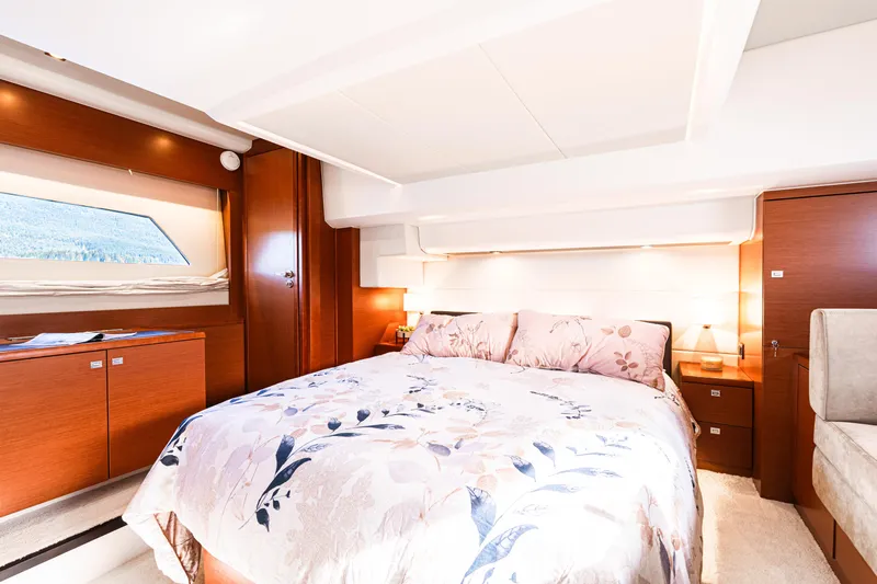 Luna Maris Yacht Photos Pics Luxurious bedroom interior of 2016 Prestige 550 yacht with elegant wood finishes and floral bedding.