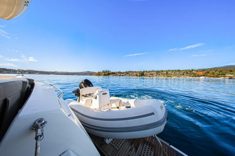 Luna Maris Yacht Photos Pics Luxury yacht Prestige 550 on serene water with scenic shoreline view, 2016 model.