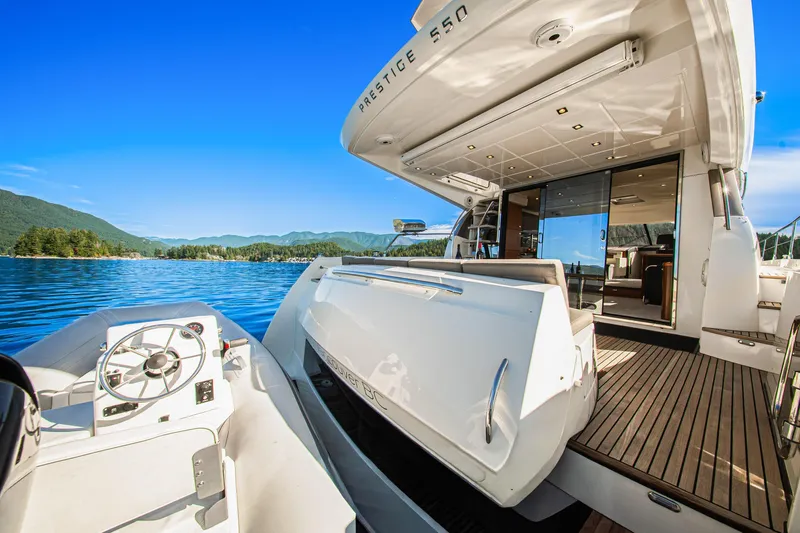 Luna Maris Yacht Photos Pics Luxury 2016 Prestige 550 yacht on serene lake with scenic mountain backdrop.