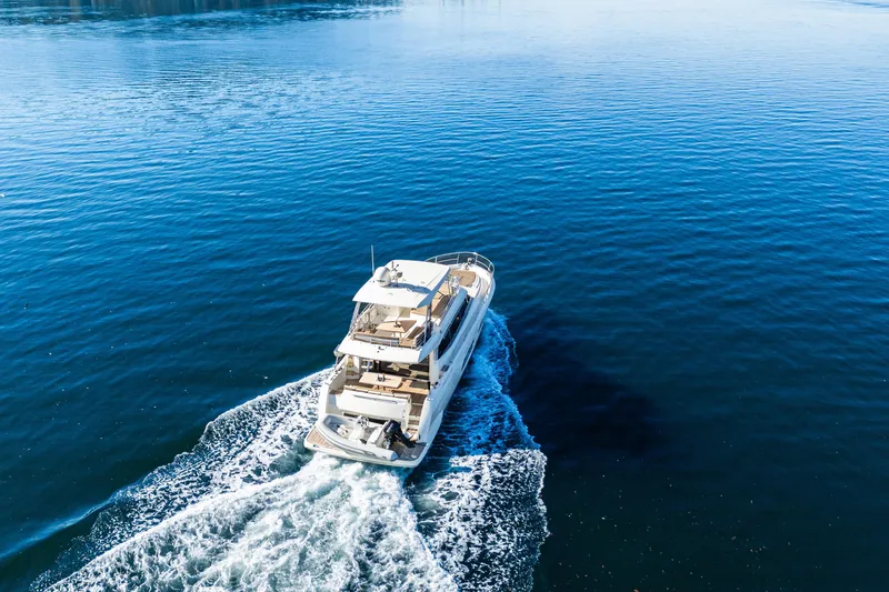 Luna Maris Yacht Photos Pics Aerial view of 2016 Prestige 550 yacht cruising on calm blue waters.