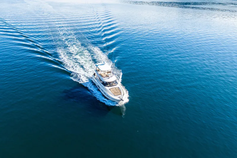 Luna Maris Yacht Photos Pics Aerial view of 2016 Prestige 550 yacht cruising on calm blue waters.