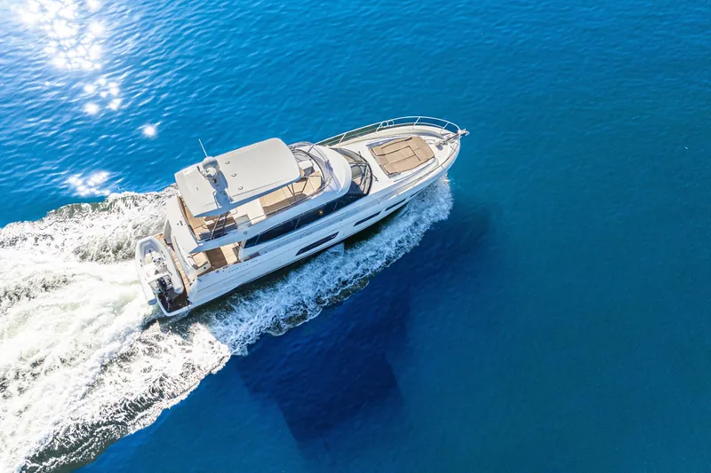 Luna Maris Yacht Photos Pics Aerial view of 2016 Prestige 550 yacht cruising on blue ocean waters.