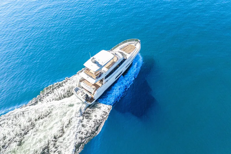 Luna Maris Yacht Photos Pics Aerial view of 2016 Prestige 550 yacht cruising on clear blue water.