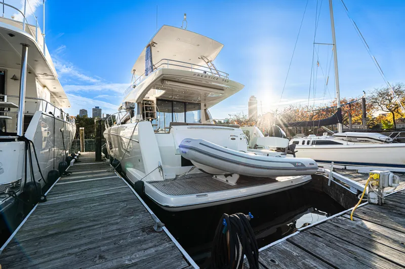 Luna Maris Yacht Photos Pics 2016 Prestige 550 yacht docked, with inflatable boat, under clear blue sky.