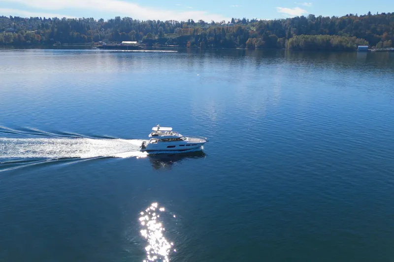 Luna Maris Yacht Photos Pics 2016 Prestige 550 yacht cruising on a serene lake under a clear blue sky.