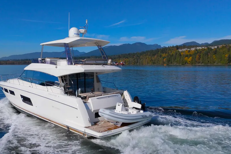 Luna Maris Yacht Photos Pics 2016 Prestige 550 yacht cruising on a scenic lake with forested hills.