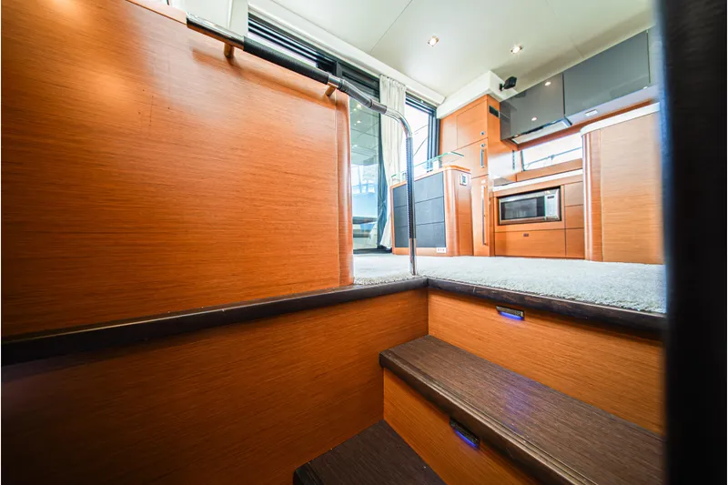 Luna Maris Yacht Photos Pics Interior of 2016 Prestige 550 yacht with wooden stairs and modern kitchen.