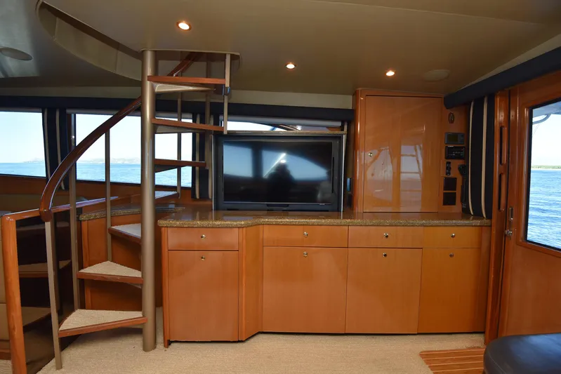 Bella Betty Yacht Photos Pics Interior of 2003 Viking 65 Enclosed Bridge yacht with spiral staircase and wooden cabinetry.