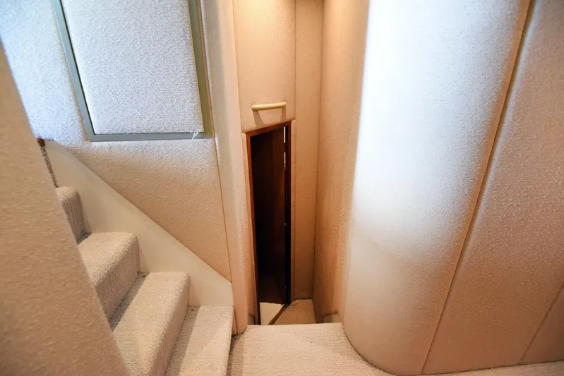 Bella Betty Yacht Photos Pics Interior staircase of 2003 Viking 65 Enclosed Bridge yacht, featuring carpeted steps and walls.