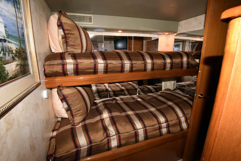 Bella Betty Yacht Photos Pics Bunk beds in 2003 Viking 65 Enclosed Bridge yacht cabin with striped bedding.
