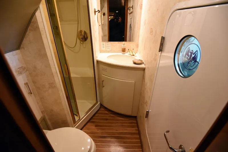 Bella Betty Yacht Photos Pics Bathroom interior of 2003 Viking 65 Enclosed Bridge yacht with shower and wooden flooring.