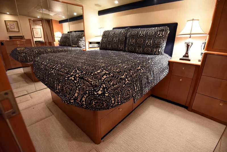 Bella Betty Yacht Photos Pics Luxurious bedroom interior of 2003 Viking 65 Enclosed Bridge yacht with elegant bedding and warm lighting.