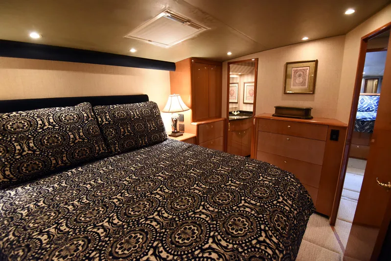 Bella Betty Yacht Photos Pics Luxurious bedroom interior of 2003 Viking 65 Enclosed Bridge yacht with elegant bedding and warm lighting.