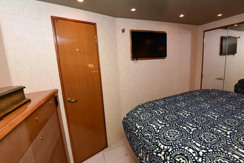 Bella Betty Yacht Photos Pics Interior of 2003 Viking 65 Enclosed Bridge yacht bedroom with TV and patterned bedding.