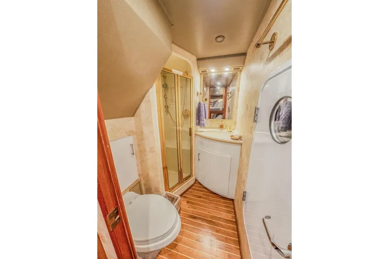 Bella Betty Yacht Photos Pics Luxurious bathroom in 2003 Viking 65 Enclosed Bridge yacht with shower and wooden flooring.