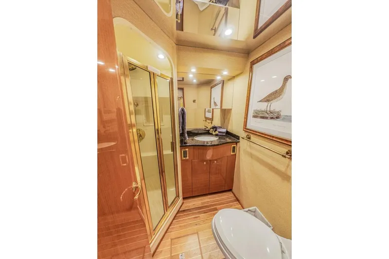 Bella Betty Yacht Photos Pics Luxurious bathroom in 2003 Viking 65 Enclosed Bridge yacht with elegant wood and gold accents.