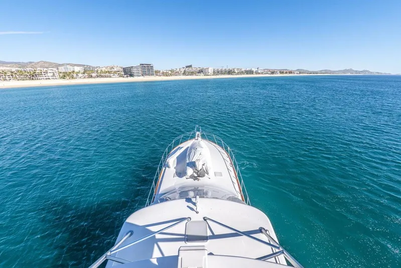Bella Betty Yacht Photos Pics 2003 Viking 65 Enclosed Bridge yacht cruising towards scenic coastline.