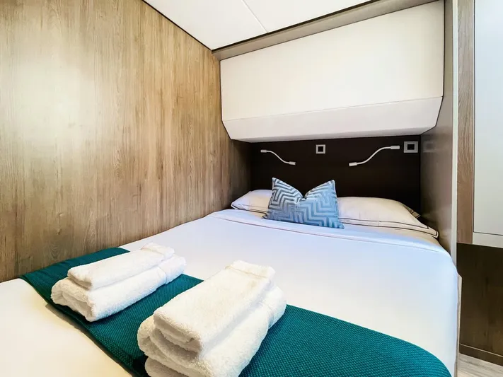 Signature Bali 5.4. (6+ 2 Cabins) Yacht Photos Pics Cozy bedroom in 2022 Bali 5.4 model yacht with neatly arranged towels and pillows.