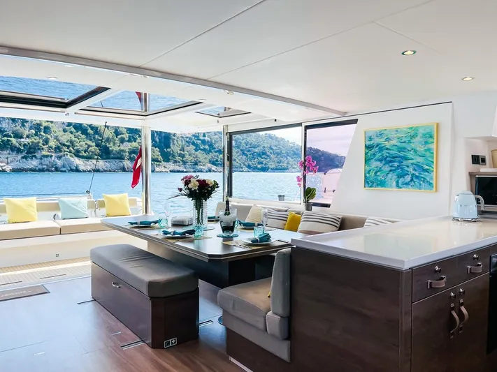 Signature Bali 5.4. (6+ 2 Cabins) Yacht Photos Pics Luxurious Bali 5.4 yacht interior with elegant dining area, scenic ocean view, and modern decor, 2022 model.