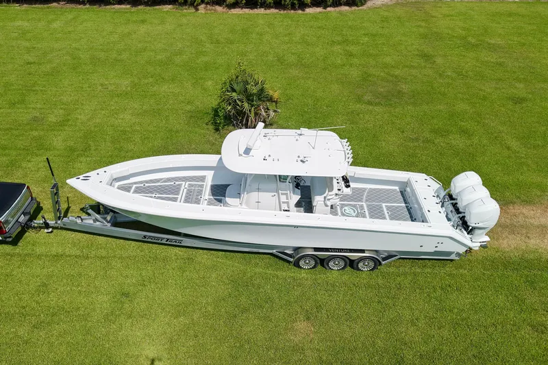  Yacht Photos Pics 2005 Venture 39 Open boat on trailer, parked on lush green grass.