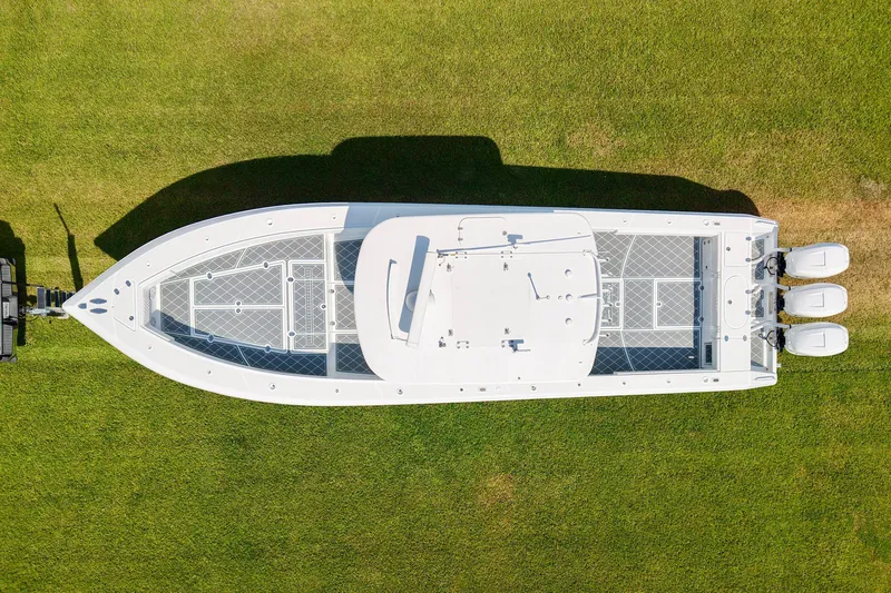  Yacht Photos Pics Aerial view of 2005 Venture 39 Open boat on grass, featuring triple outboard engines.