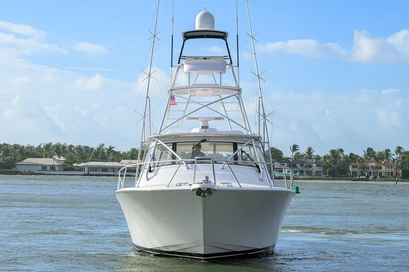  Yacht Photos Pics 2015 Viking 52 Open yacht on calm water, with coastal homes in the background.
