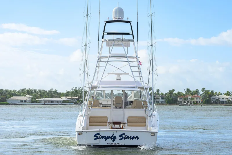  Yacht Photos Pics 2015 Viking 52 Open yacht on water, rear view, with coastal homes in background.