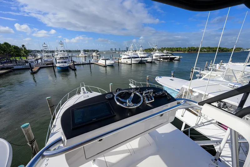 Yacht Photos Pics Helm view from 2015 Viking 52 Open yacht at marina with boats and blue sky.