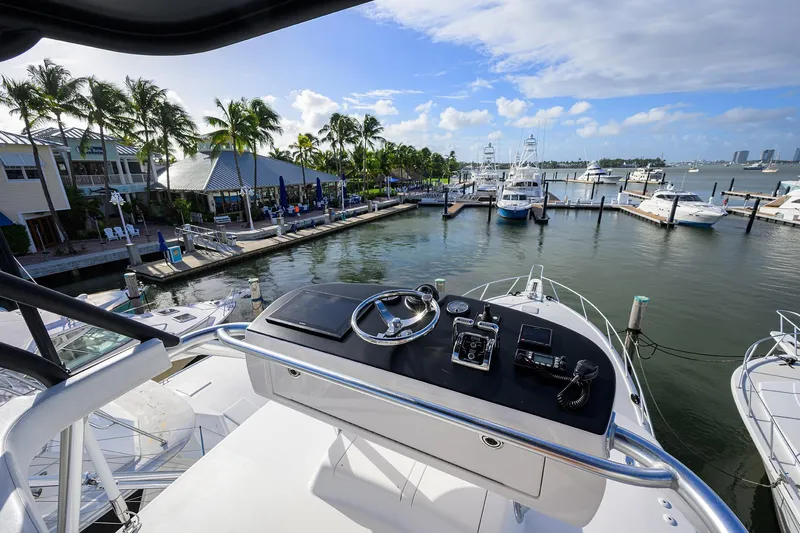  Yacht Photos Pics Flybridge view from 2015 Viking 52 Open yacht docked at a marina with palm trees.