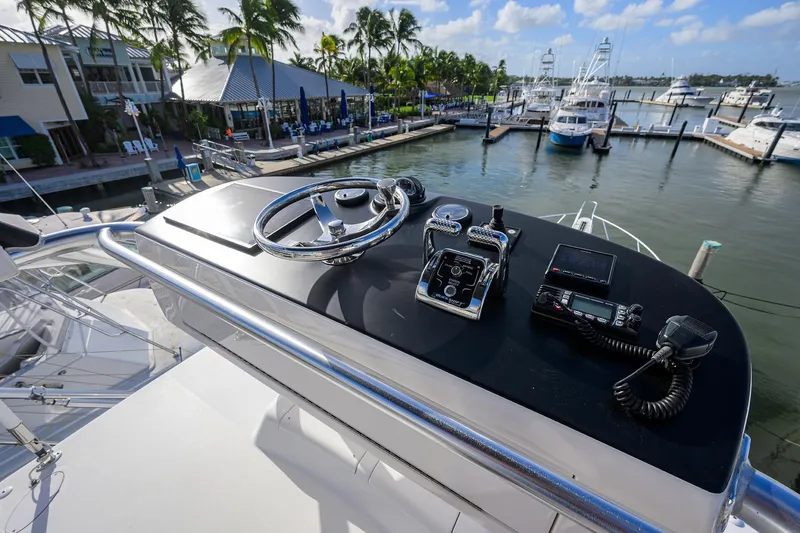  Yacht Photos Pics Helm of 2015 Viking 52 Open yacht at marina with palm trees and boats.