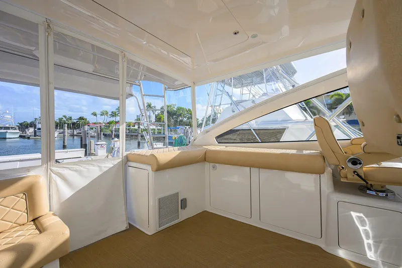  Yacht Photos Pics Interior view of 2015 Viking 52 Open yacht with beige seating and marina backdrop.