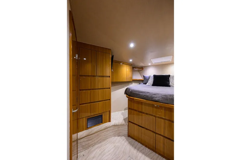  Yacht Photos Pics Luxurious cabin interior of 2015 Viking 52 Open yacht with wood cabinetry and cozy bedding.