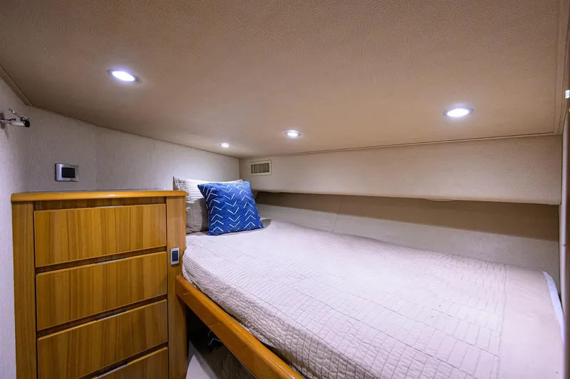  Yacht Photos Pics 2015 Viking 52 Open yacht cabin with bed, wooden dresser, and ambient lighting.