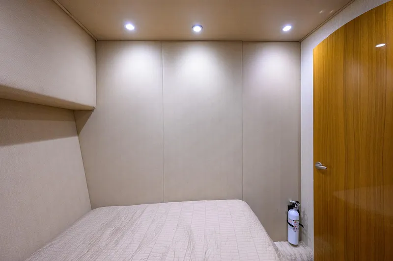  Yacht Photos Pics 2015 Viking 52 Open yacht cabin interior with bed, wooden door, and fire extinguisher.