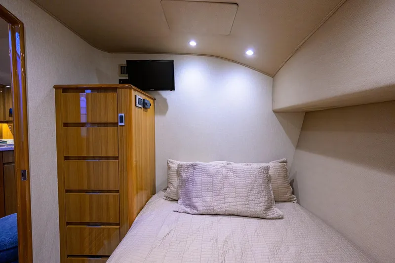  Yacht Photos Pics 2015 Viking 52 Open yacht cabin with bed, wooden cabinet, and wall-mounted TV.