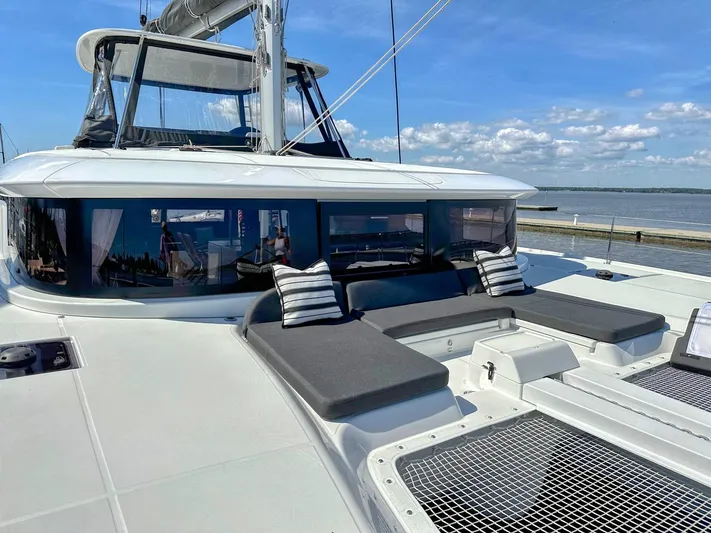 Sogno Yacht Photos Pics 2024 Lagoon 46 catamaran with spacious deck and seating, docked by the water.