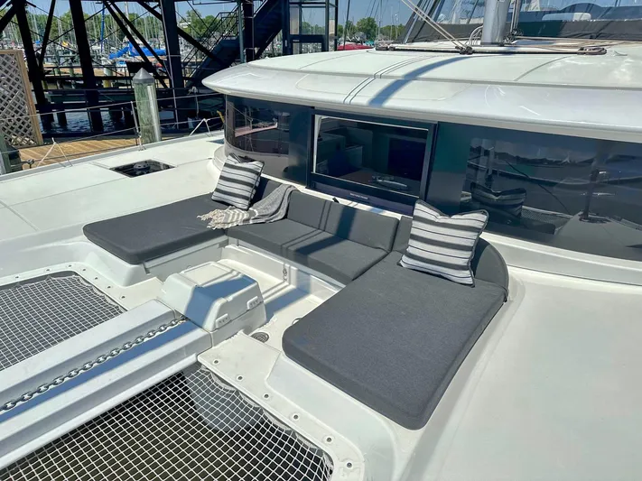 Sogno Yacht Photos Pics 2024 Lagoon 46 catamaran with cushioned seating and striped pillows on deck.