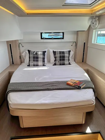 Sogno Yacht Photos Pics Luxurious 2024 Lagoon 46 yacht cabin with cozy bed and modern decor.