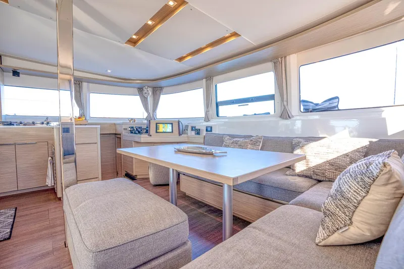 Sogno Yacht Photos Pics Luxurious interior of 2024 Lagoon 46 yacht with modern seating and large windows.