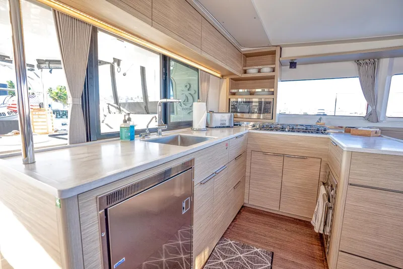 Sogno Yacht Photos Pics Modern kitchen interior of 2024 Lagoon 46 yacht with sleek cabinetry and appliances.