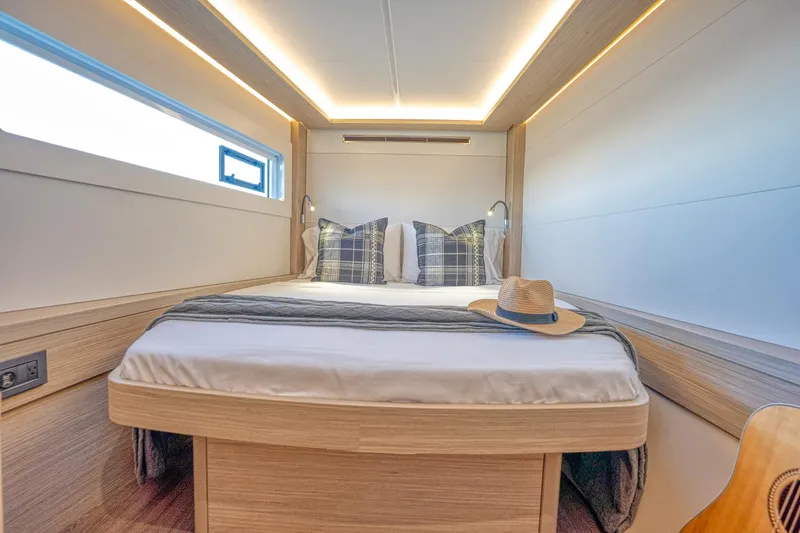 Sogno Yacht Photos Pics Luxurious cabin interior of 2024 Lagoon 46 yacht with cozy bed and stylish decor.