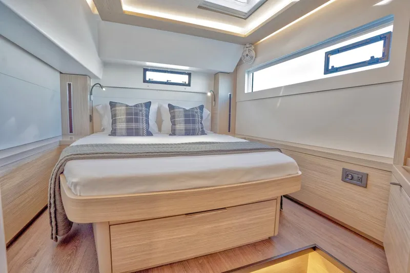 Sogno Yacht Photos Pics Luxurious cabin interior of 2024 Lagoon 46 yacht with modern design and cozy bedding.