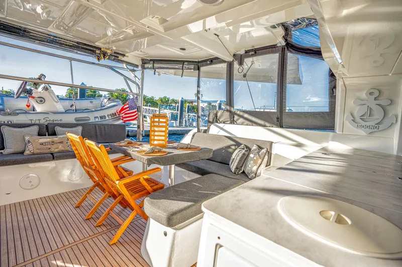 Sogno Yacht Photos Pics Luxurious 2024 Lagoon 46 yacht interior with seating, table, and scenic marina view.