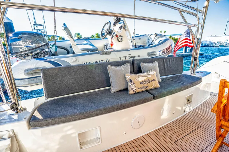 Sogno Yacht Photos Pics 2024 Lagoon 46 yacht with cushioned seating, decorative pillows, and a view of the marina.