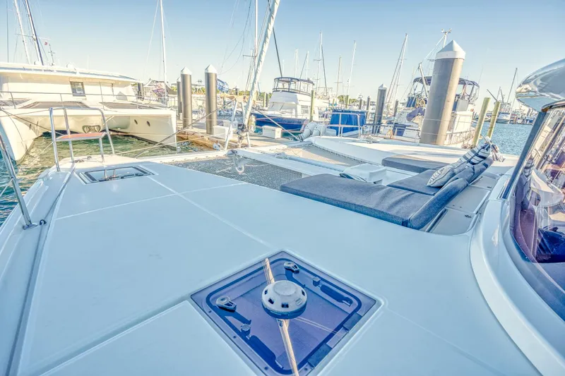 Sogno Yacht Photos Pics 2024 Lagoon 46 catamaran docked at marina with spacious deck and seating area.