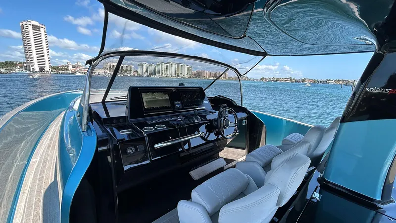 Yacht Photos Pics 2022 Solaris Power 44 yacht interior with modern helm, overlooking scenic waterfront cityscape.