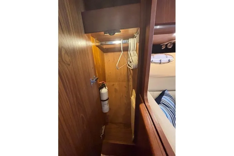 The Riddler Yacht Photos Pics 2009 Tiara Yachts 3600 Open interior closet with hangers and fire extinguisher.